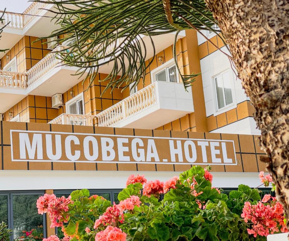 un hotel con un cartel frente a un edificio en Mucobega Hotel, en Sarandë