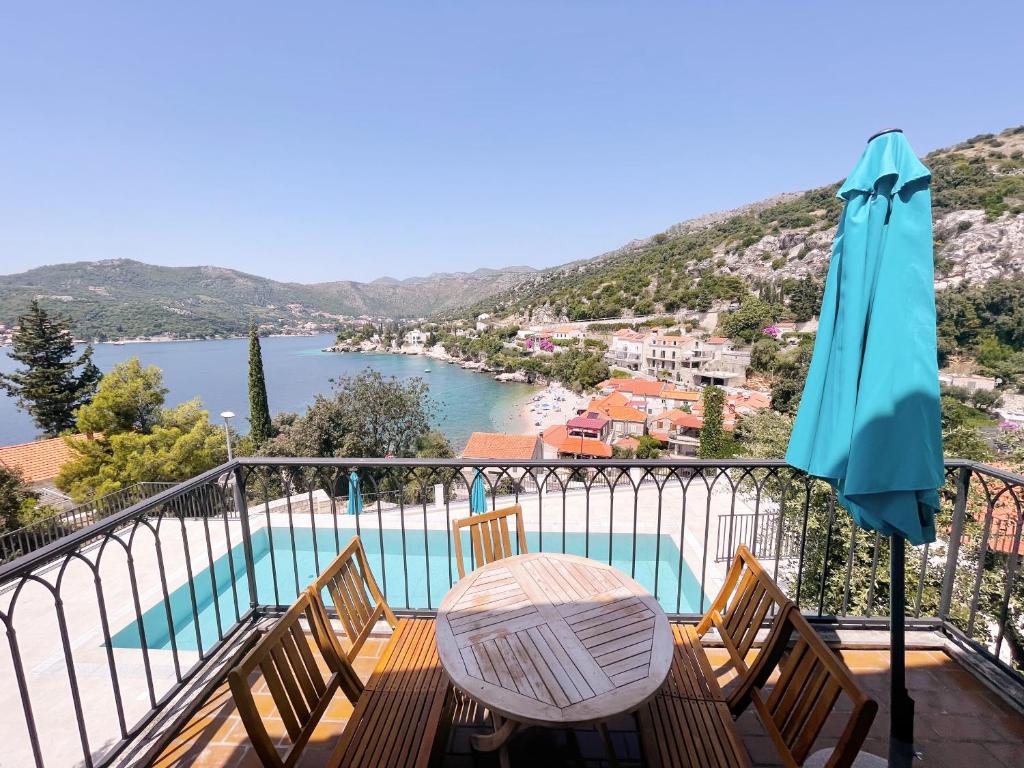 a patio with a table and chairs and an umbrella at Apartments Villa Marijeta with Free Parking in Zaton