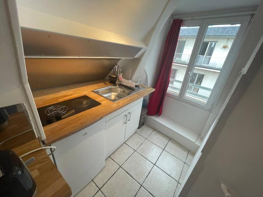 a small kitchen with a sink and a window at Jupiter 3 YourHostHelper in Caen