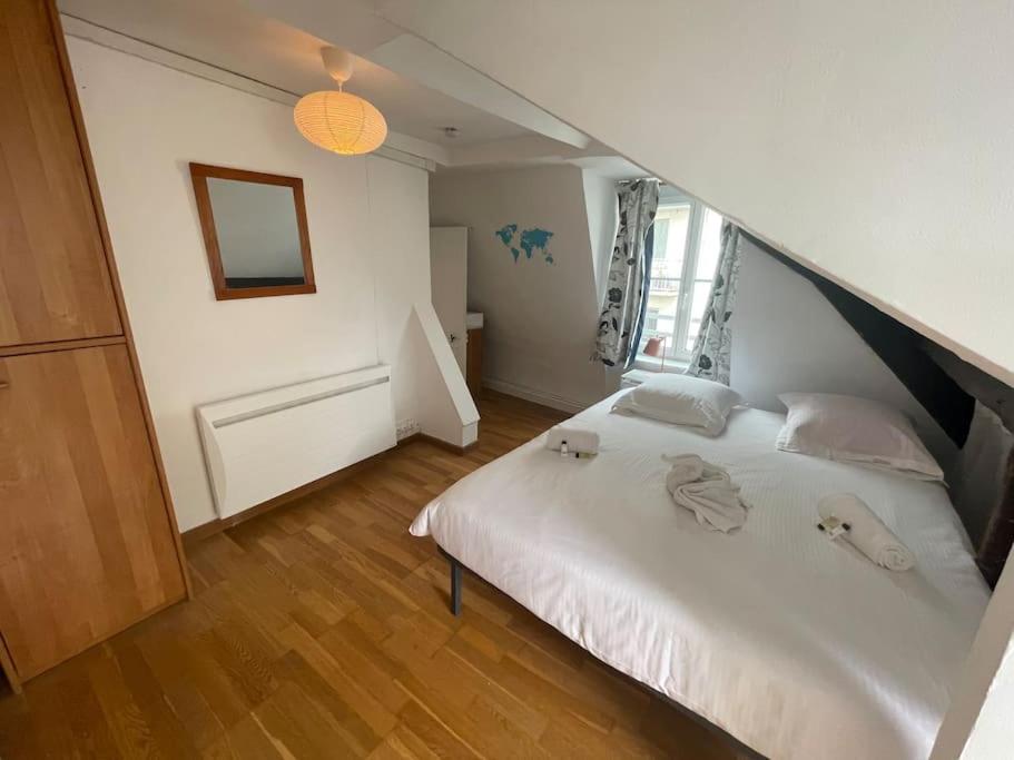 a bedroom with a white bed and a staircase at Jupiter 3 YourHostHelper in Caen