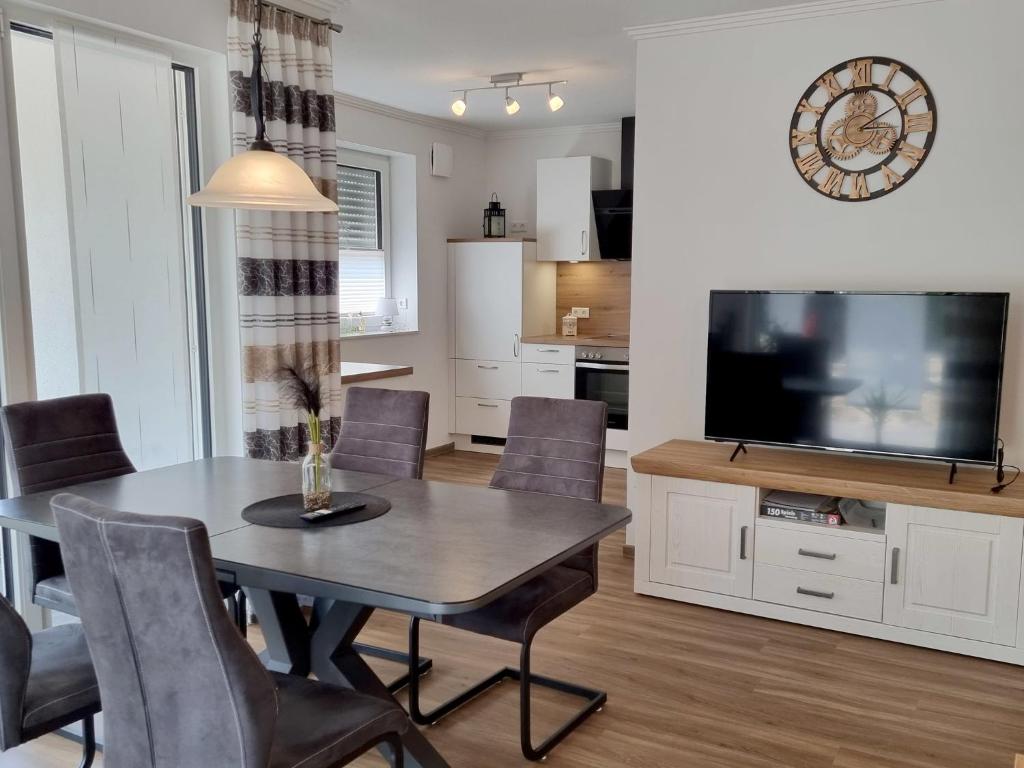 a dining room and kitchen with a table and a television at Ferienwohnung Angela - a90191 in Walchum