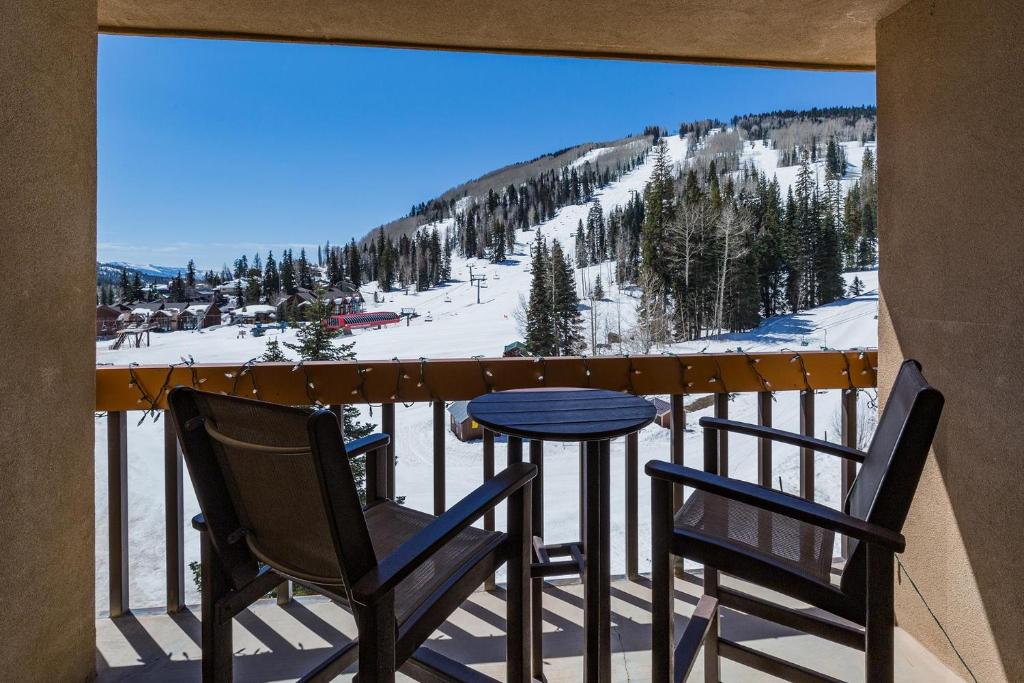 a balcony with two chairs and a table and a ski slope at Village Center 611 in Durango Mountain Resort