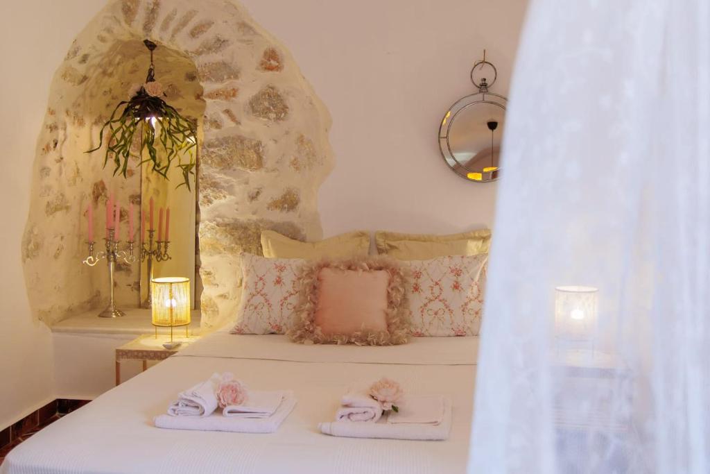 - une chambre avec un lit et des serviettes dans l'établissement Iliana's house - spacious cave house in the center of Areopolis, à Areópoli