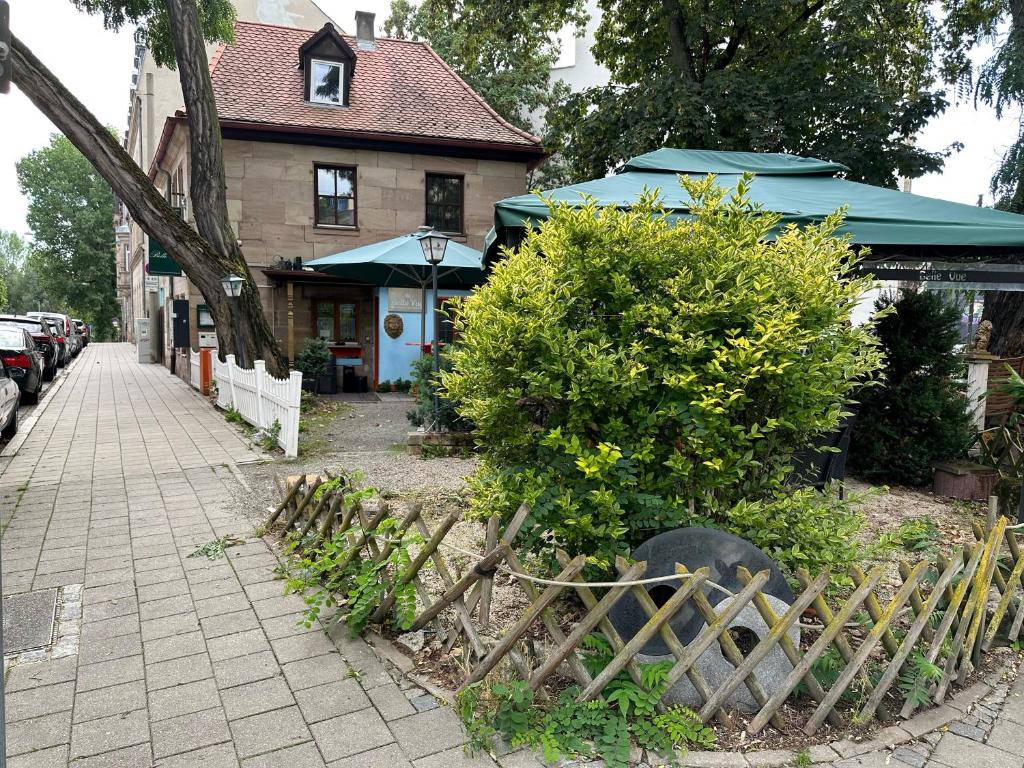 a wooden fence next to a house with bushes at Belle Vue in Fürth