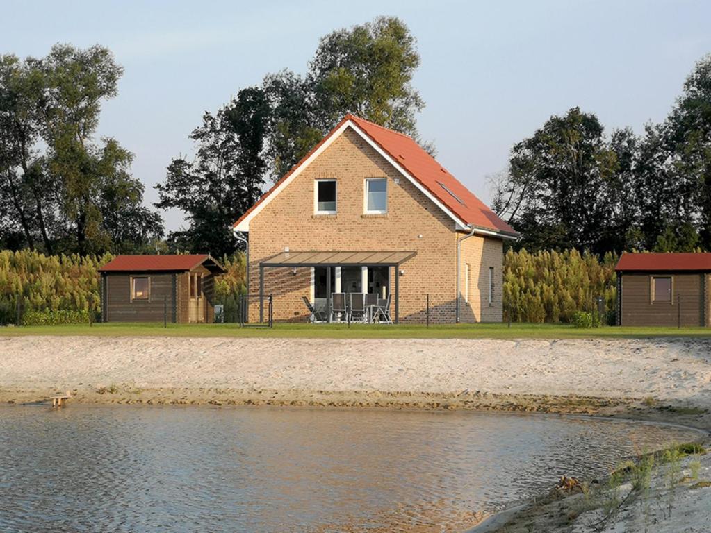 a house on the shore of a body of water at Seehaus Luddenhof 1 - a90196 in Walchum