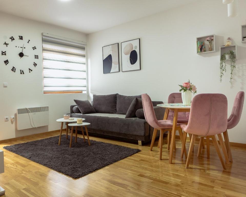 ein Wohnzimmer mit einer Couch und einem Tisch und Stühlen in der Unterkunft Flora Lux and Spa Zlatibor in Zlatibor