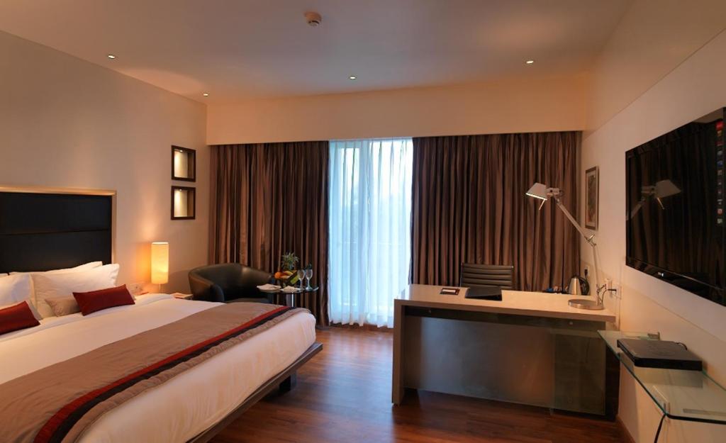 Habitación de hotel con cama grande y escritorio. en Spree Shivai Hotel Pune, en Pune