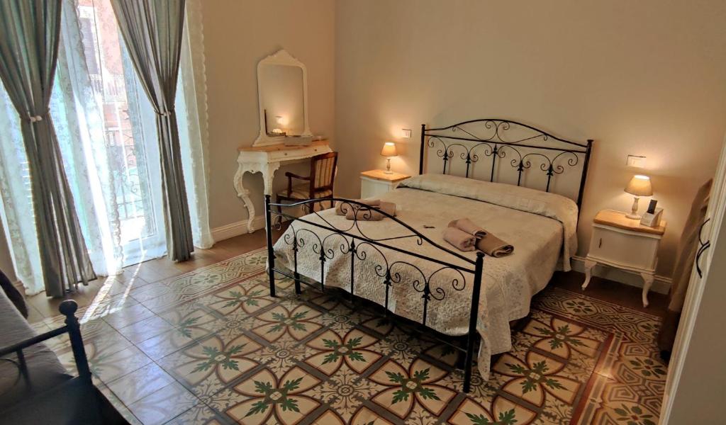 Schlafzimmer mit einem Bett, einem Tisch und einem Spiegel in der Unterkunft Belle Époque in Taranto