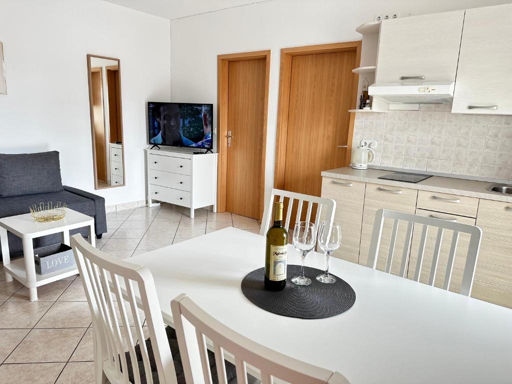 a living room with a white table with wine glasses on it at Apartments Vojvoda in Poreč