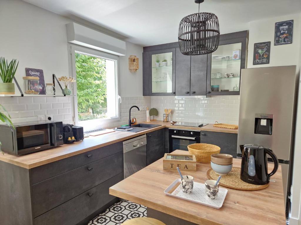 a kitchen with a wooden counter top and a sink at Appartement Spacieux avec Parking proche MER in Saint-Nazaire