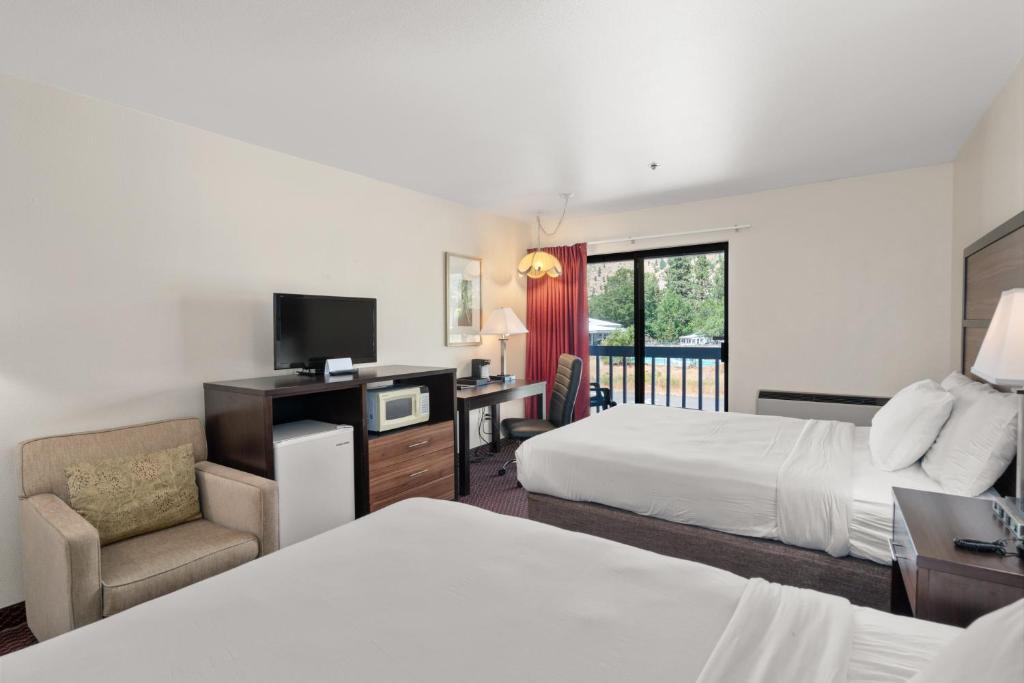 una habitación de hotel con 2 camas y una silla en Wedge Mountain Inn, en Leavenworth
