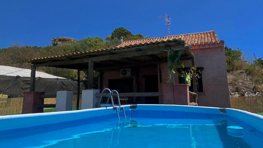 uma casa com piscina em frente a uma casa em Casa de campo Espinosa em La Garnatilla