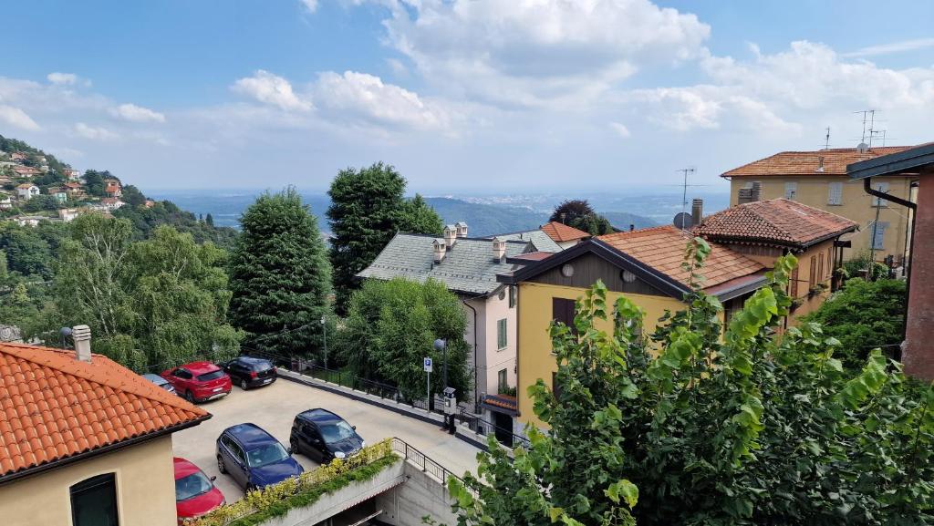 a town with cars parked in a parking lot at Appartamenti Monti Como Lake in Brunate