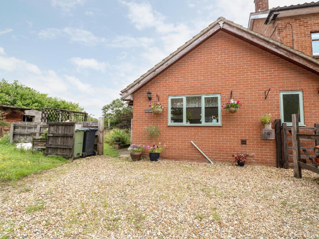 a brick house with a window and a yard at Deer Cottage in Thompson