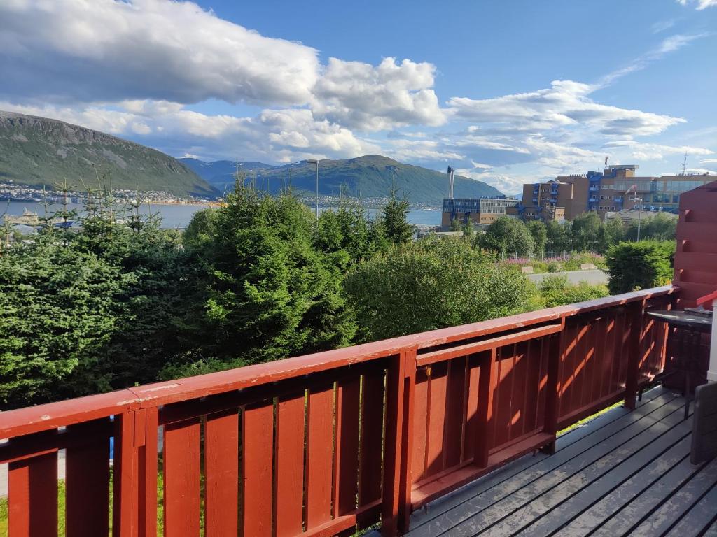 a wooden deck with a view of a body of water at FeelHome 3 bedroom Near University in Tromsø
