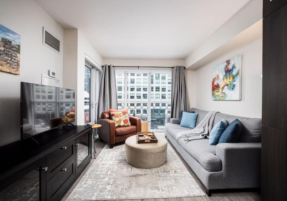 ein Wohnzimmer mit Couch und Fernseher in der Unterkunft Welcoming Downtown Condo with WFH setup Balcony in Toronto