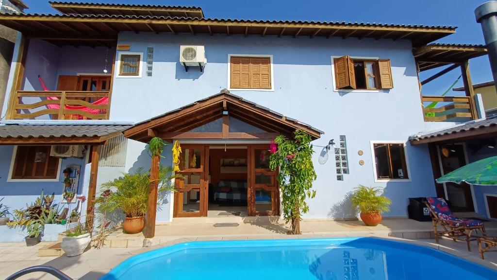 a house with a swimming pool in front of it at Nuna Hostel Floripa in Florianópolis