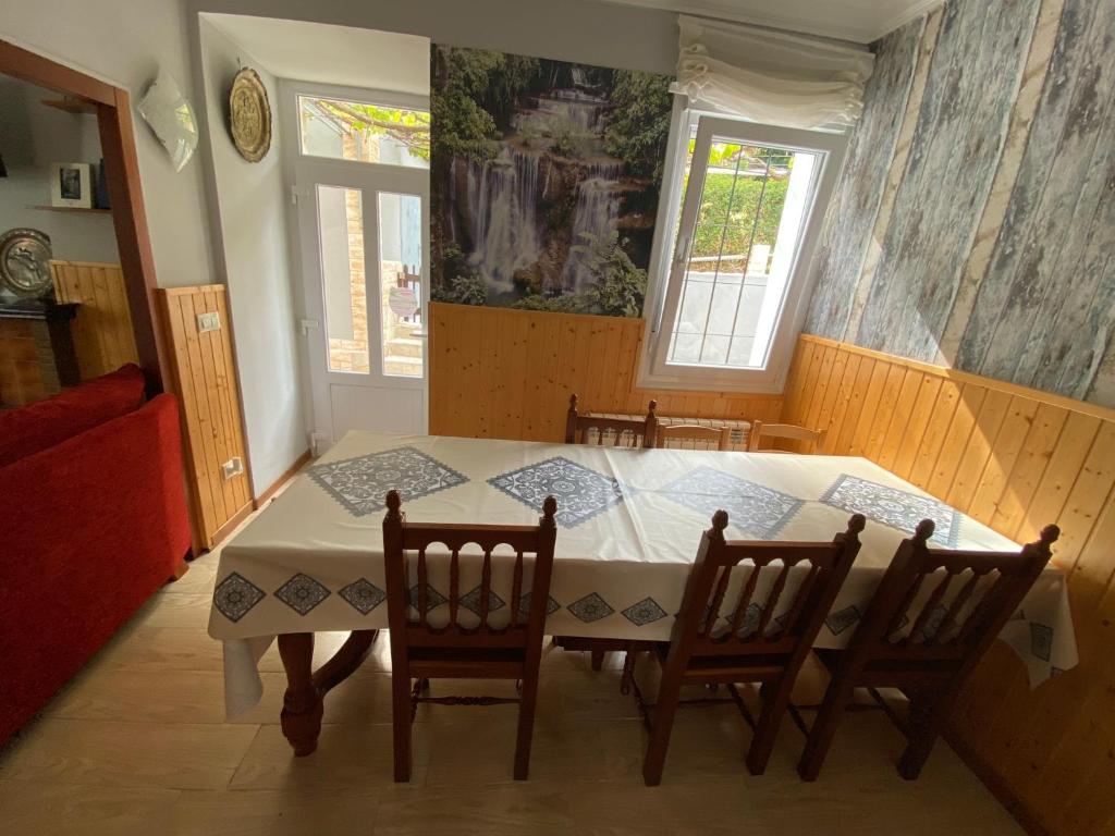 a dining room with a white table and chairs at Chalet Rialeda in Oleiros