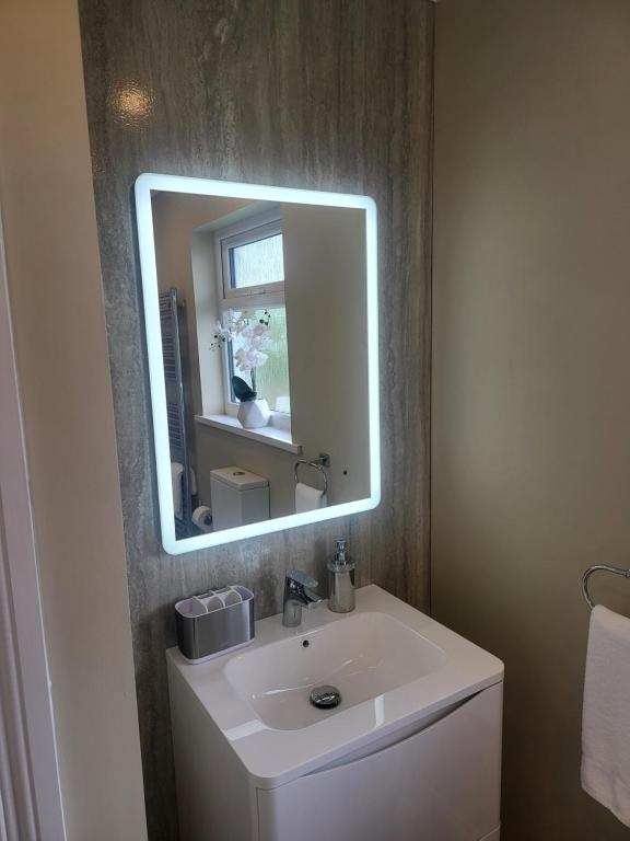 a bathroom with a white sink and a mirror at Royal Court Hotel in Portrush