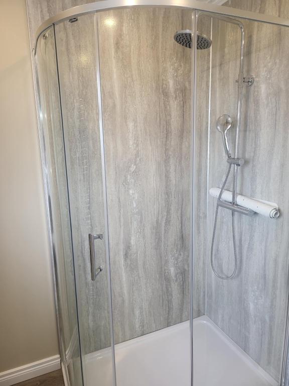 a shower with a glass door in a bathroom at Royal Court Hotel in Portrush