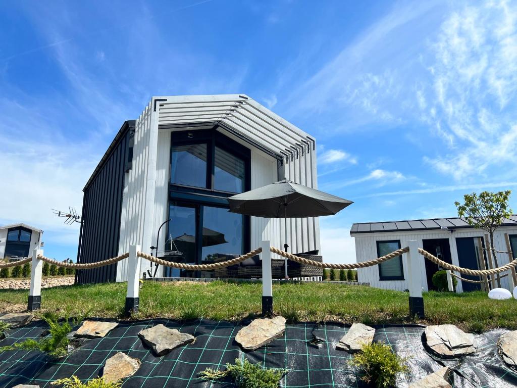 une maison avec un parasol et quelques pierres dans l'établissement Casa Kashubia, à Brzeźno Szlacheckie