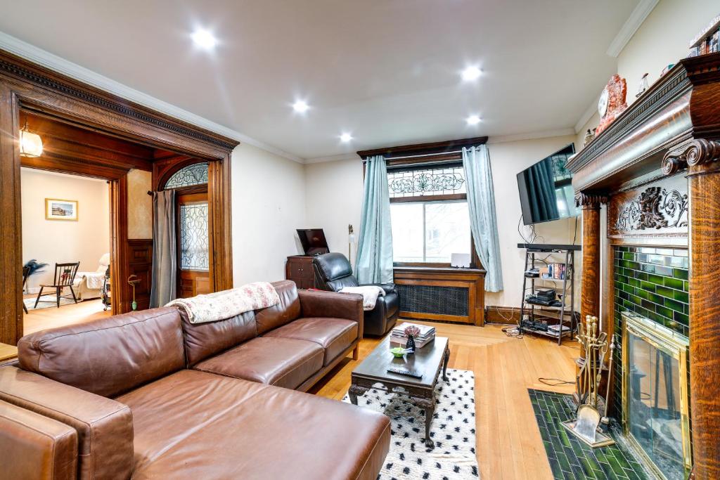 a living room with a leather couch and a fireplace at Spacious Pittsburgh Rental Walk to Frick Park! in Pittsburgh