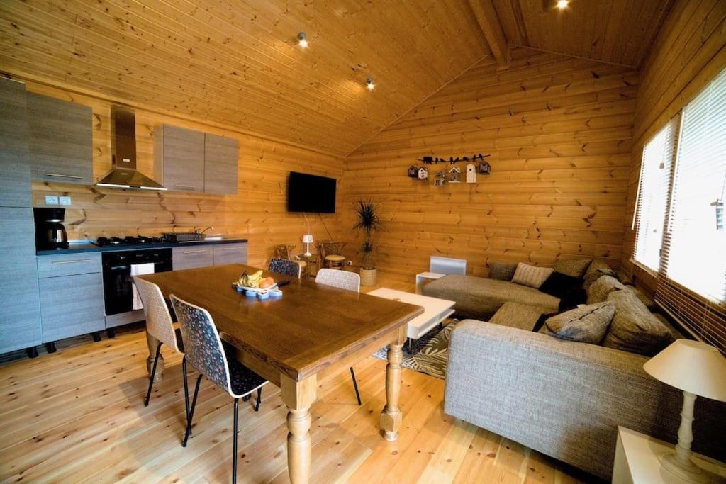 ein Wohnzimmer mit Tisch und Couch in der Unterkunft Cottage autour de l'étang 80 in Bourbourg