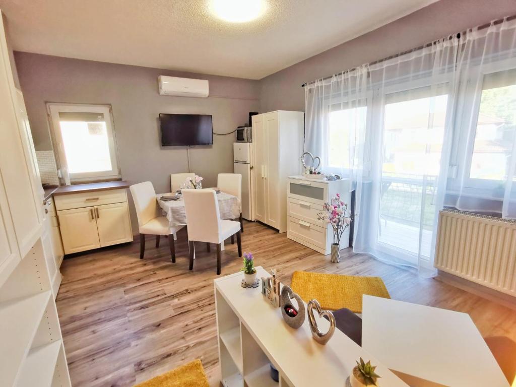 a living room with a kitchen and a dining room at Panoráma Garden in Zalakaros