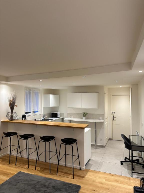 een keuken met een aanrecht en krukken in een kamer bij Super appartement refait à neuf beaucoup de charme in Boulogne-Billancourt