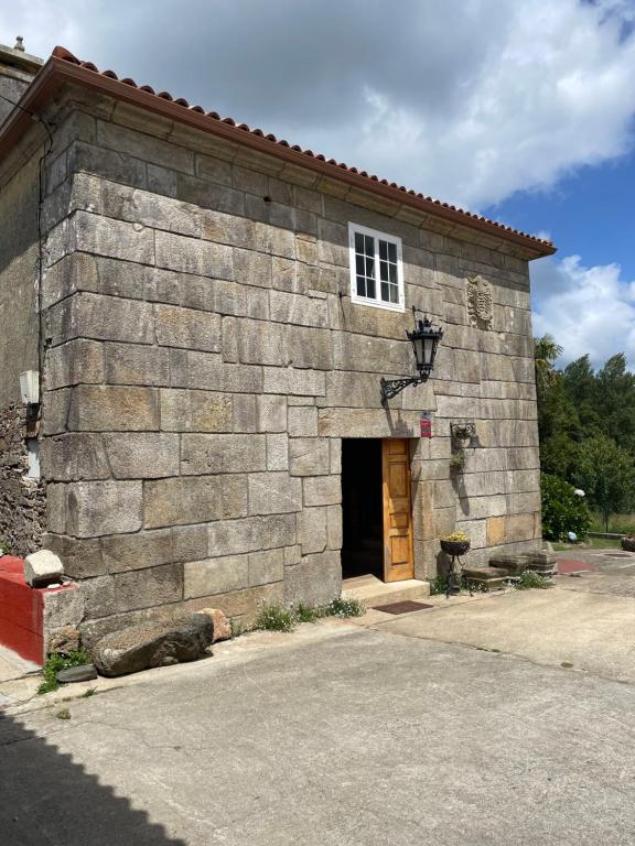 un edificio de piedra con puerta y ventana en CASA DE PARDO, en A Coruña