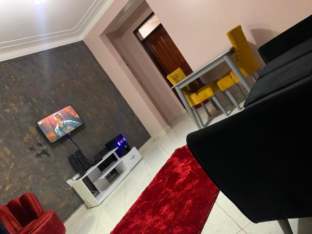 a living room with a couch and a red rug at Thee Haven 3 in Kampala