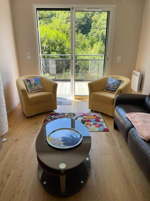 un salon avec deux chaises et une table basse dans l'établissement Le B4 - Résidence La Montille, à Le Mont-Dore