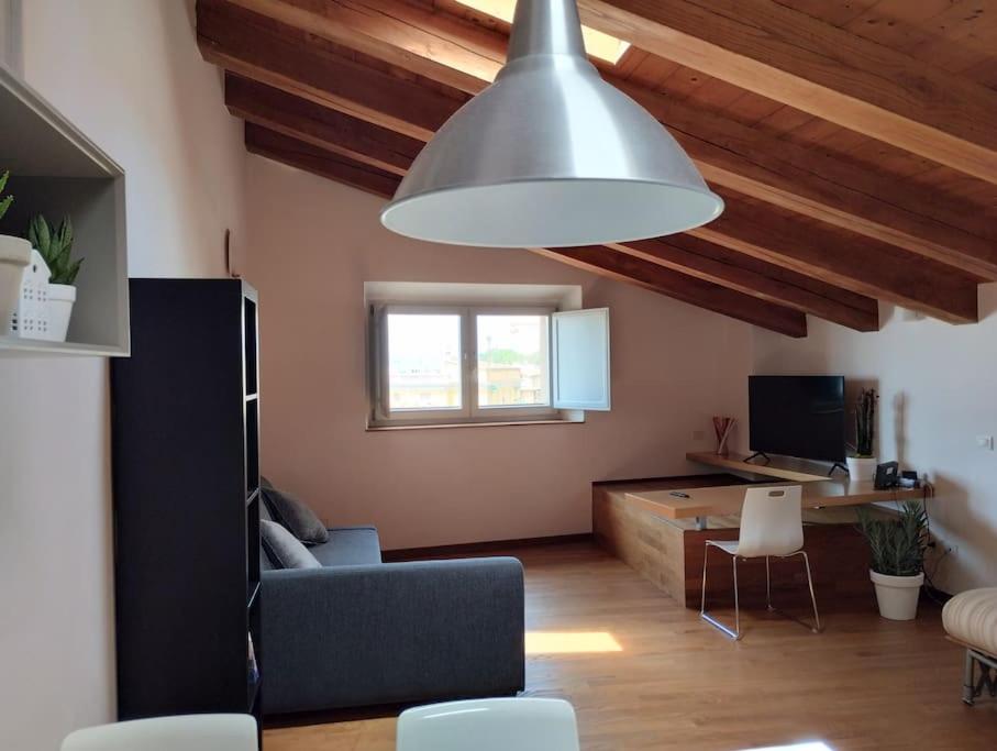 een woonkamer met een bank en een grote lamp bij La Finestra sul Porto Apartment in Ancona