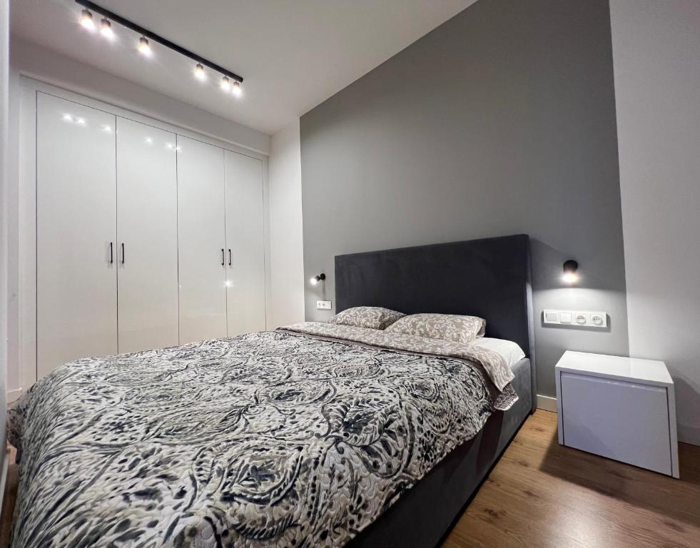 een slaapkamer met een bed met een zwart-wit dekbed bij K22 Large Apart Slawinska 509 in Warschau