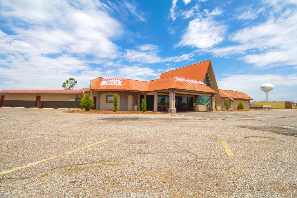 un parcheggio vuoto di fronte a un edificio di American Best Inn By OYO I-35 Perry near Lake McMurtry a Perry