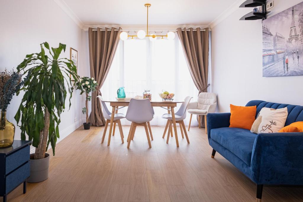 a living room with a blue couch and a table at Sublime 3 Rooms Showers in Colombes