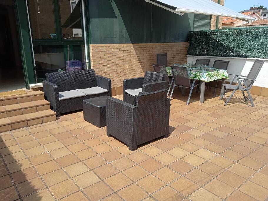 a patio with chairs and a table and a table and chairs at Apartamento L' Espumeru in Posada de Llanes
