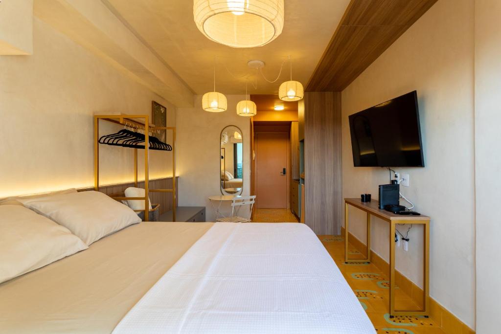 a bedroom with a large white bed and a flat screen tv at Studio Savana in São Paulo