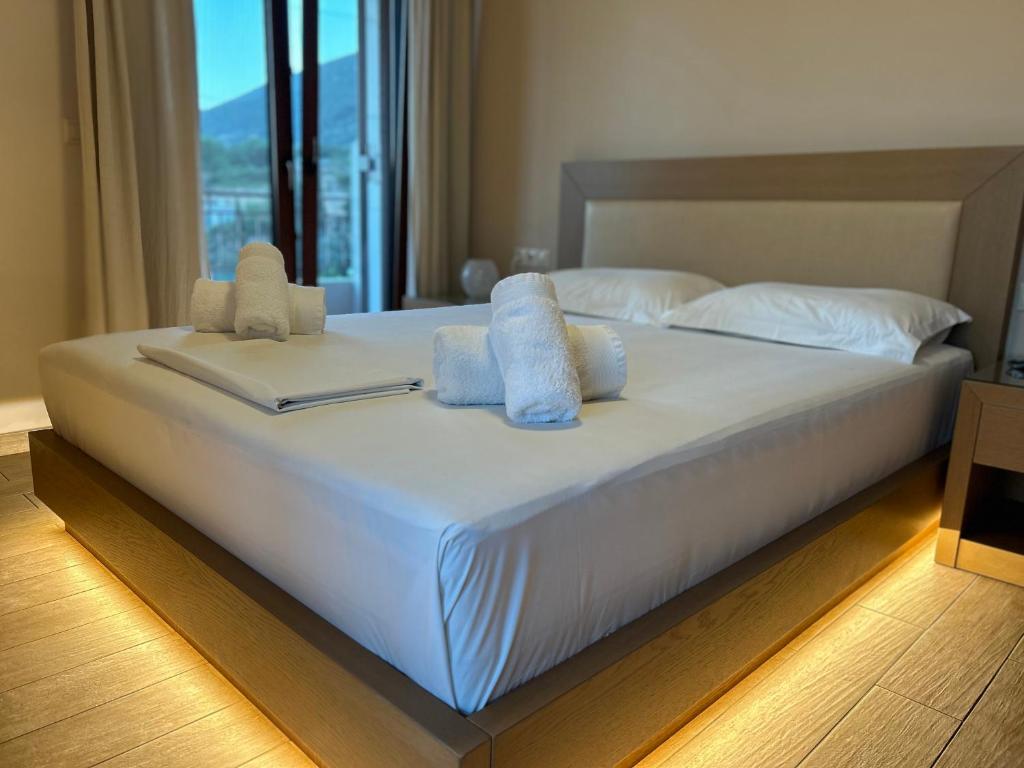 duże białe łóżko z ręcznikami na górze w obiekcie Calm View w mieście Vasiliki