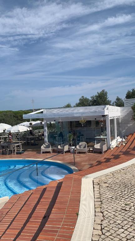 a resort with a swimming pool and a patio at appartement avec jardin privé dans une résidence hôtelière haut de gamme in Vilamoura