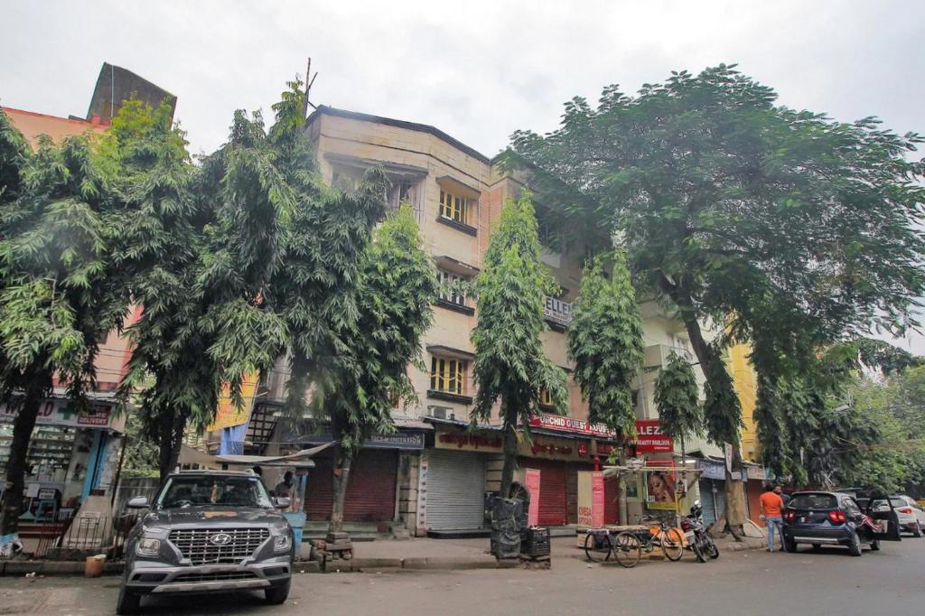 a street with cars parked in front of a building at Hotel Sai Guest House, Jadavpur kolkata in Kolkata