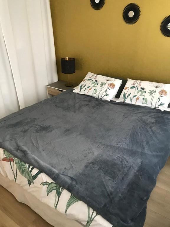 a bedroom with a bed with a black blanket on it at Appartement T2 Manoir de Malville in Nantes