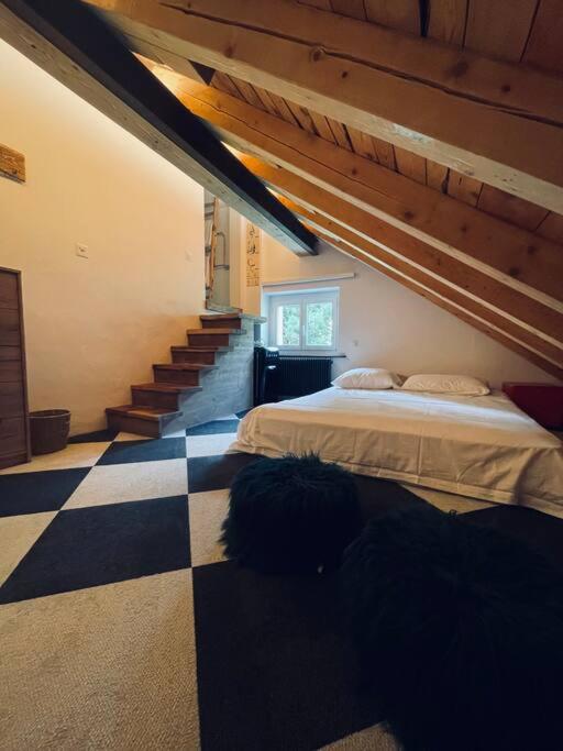 a bedroom with a bed and a checkered floor at Sottotetto grazioso St.Moritz in St. Moritz