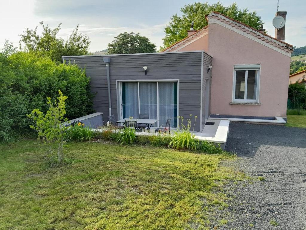 a small house with a patio in the yard at Le Chantoiseau in Unieux