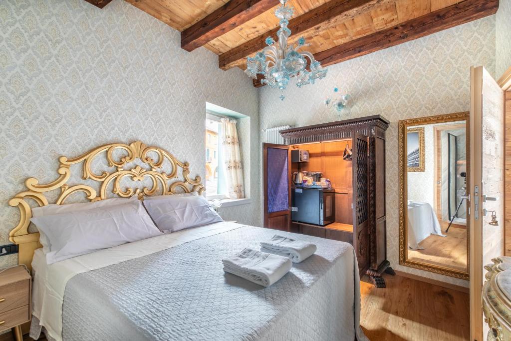 1 dormitorio con 1 cama blanca grande y espejo en b&b casa largo la piazzola, en Vittorio Veneto