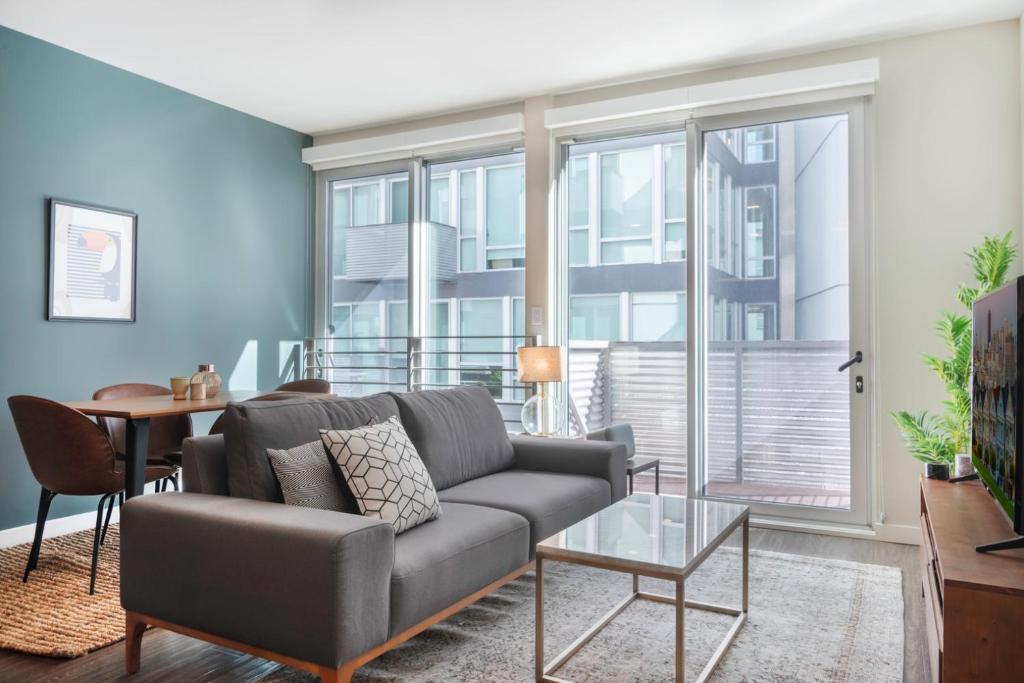ein Wohnzimmer mit Sofa und Tisch in der Unterkunft SoMa 1BR w Gym Roofdeck BBQs nr Tech HQs SFO-97 in San Francisco