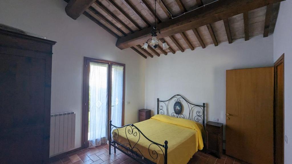 モンテプルチャーノにあるCasa Vacanze Il Faggioのベッドルーム1室(黄色い毛布付きのベッド1台付)