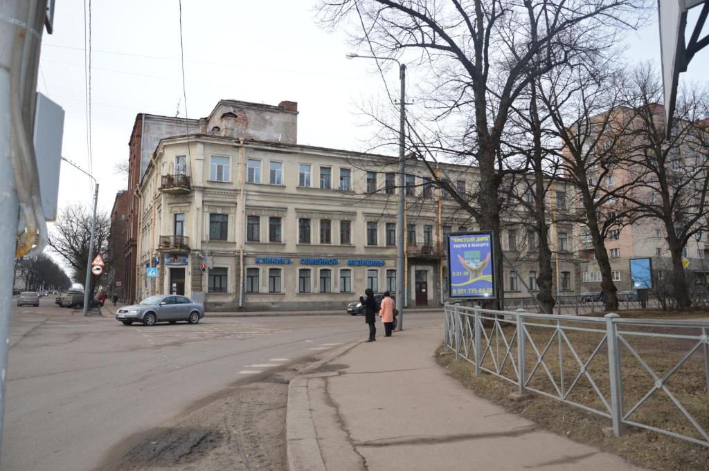 two people walking down a street in front of a building at гостевой Дом БельвеДеръ in Vyborg