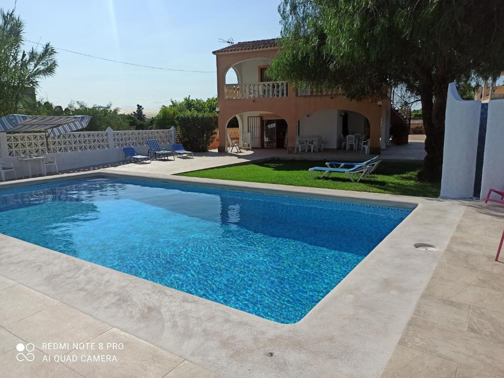 een groot zwembad voor een huis bij Villa Chalet Riomar Playa Oliva in Oliva