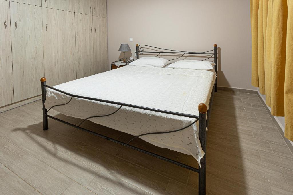 a bed in a bedroom with a wooden floor at Cosy apartment near Karfas Beach in Chios